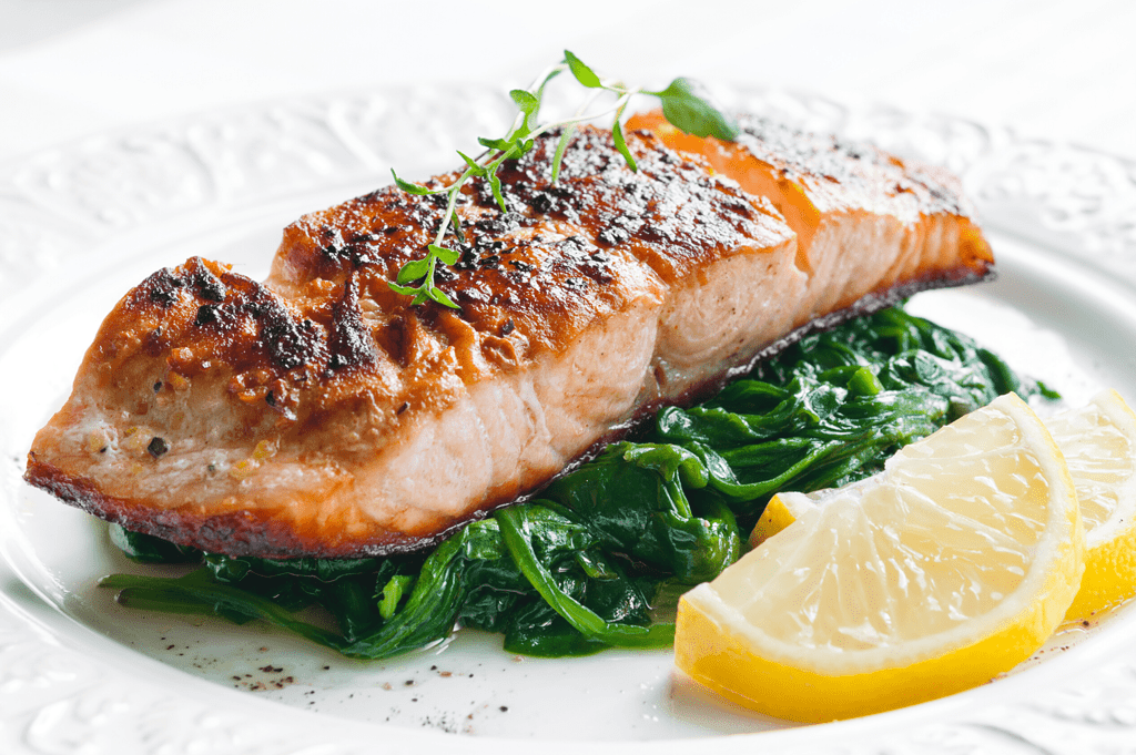 salmon and protein, one of the best foods for weight loss, on a bed of spinach