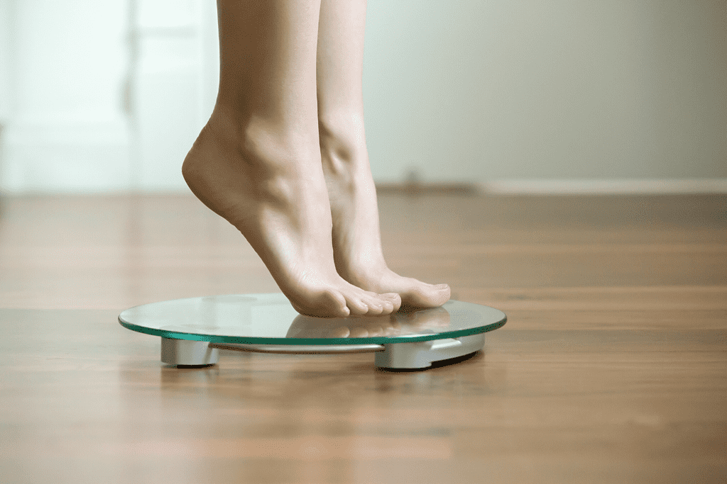 person gingerly stepping on scale to weigh yourself daily