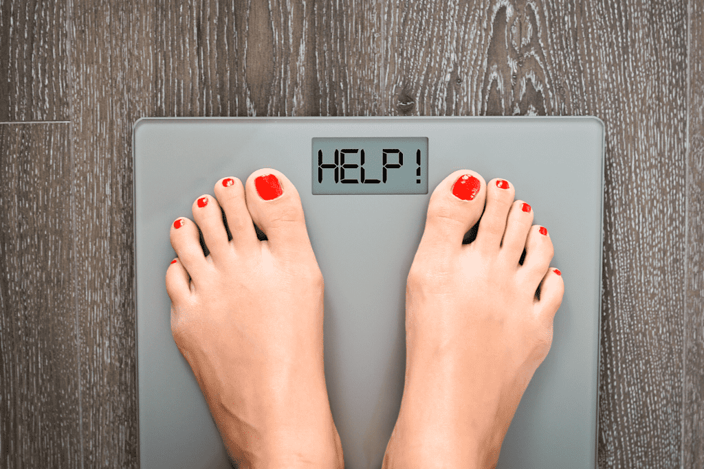 person on scale that says help instead of weight