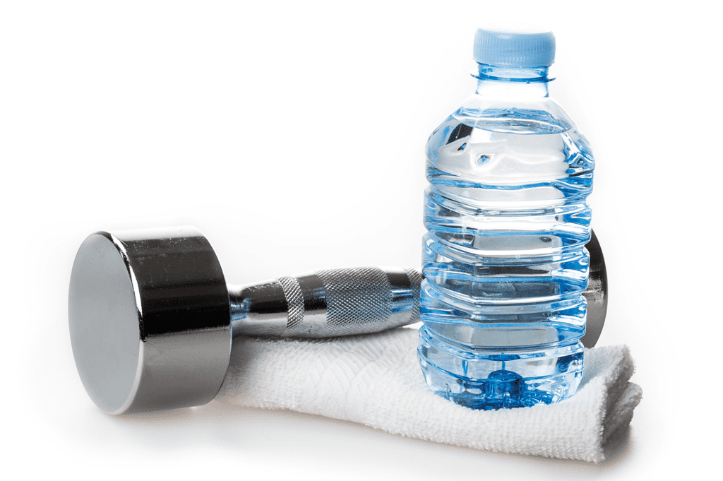 bottle of water and silver dumbbell on top of white towel