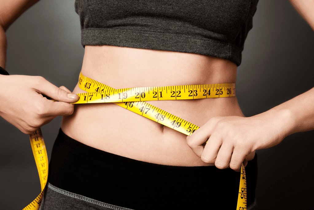 woman with tape measure around waist  enjoyed the benefits of steel cut oats for weight loss
