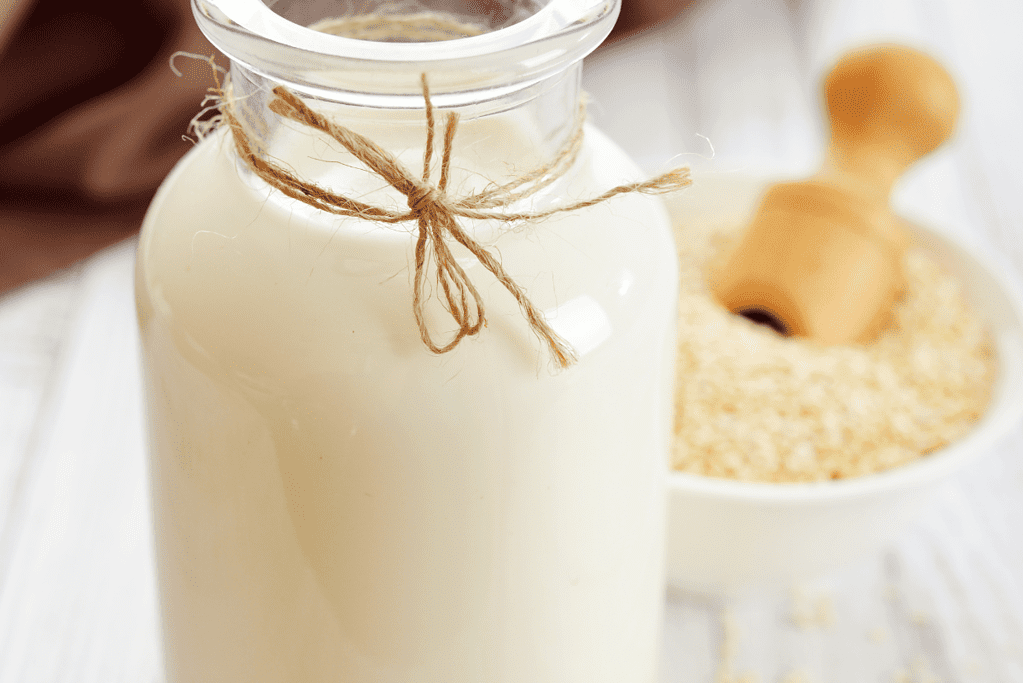 bottle of quinoa milk with bowl of quinoa
